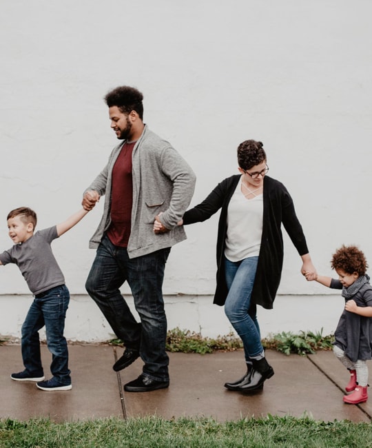 picture of a family of four walking together while holding hands